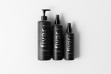 three bottles of hair products on a white background